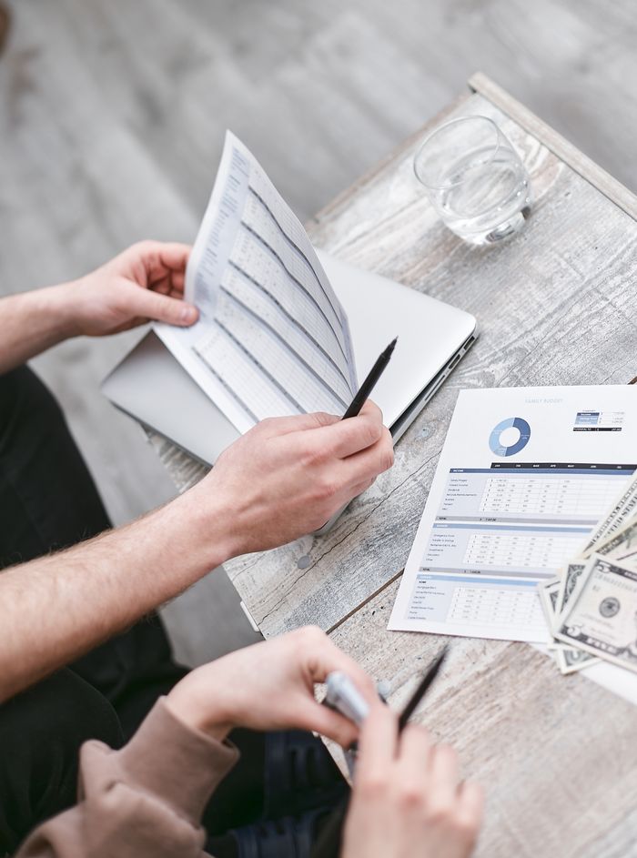 The Art of Drawing Readers In: Your attractive post title goes here Two professionals reviewing financial documents with charts, fostering collaboration.